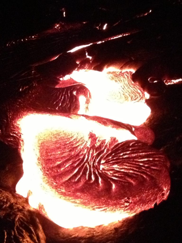 A swollen lobe of molten lava glowing white-hot at the center