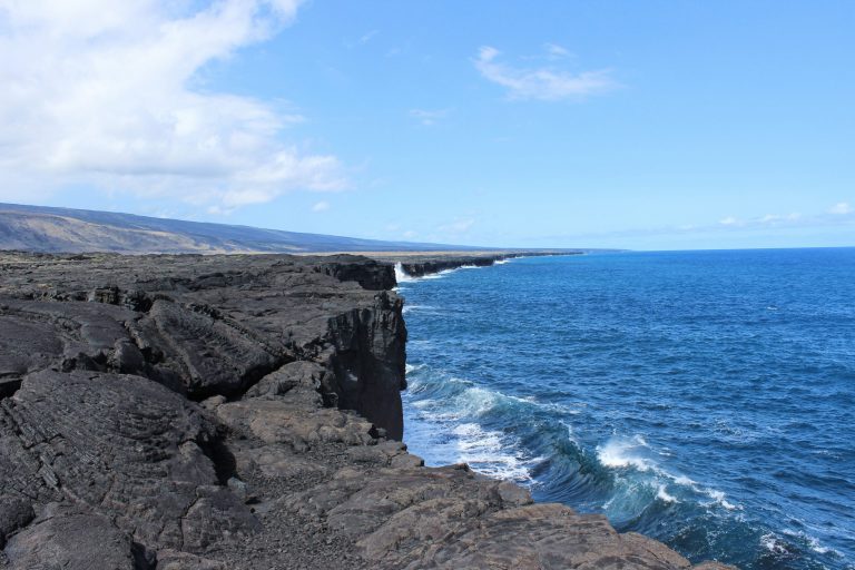Black lava sea cliffs above deep blue surf