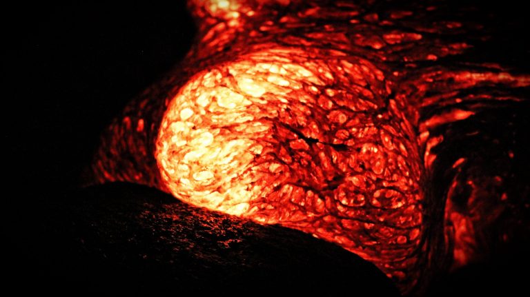 A glowing, crackled lobe of molten lava in the dark