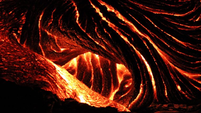 Ropy pāhoehoe lava glowing orange in the dark