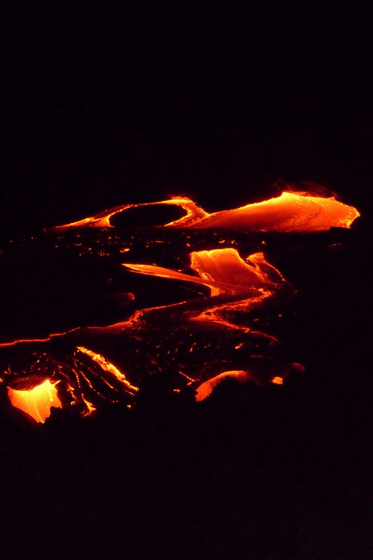 A narrow river of lava running through darkness