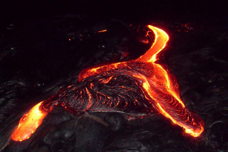 A bright lava channel cutting across a dark flow